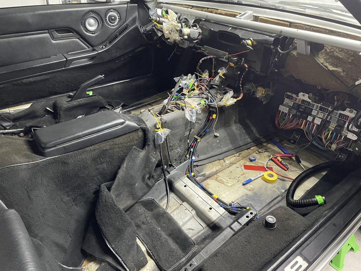 Porsche 928 interior stripped to the floor pan, exposing the wiring during the rebuild