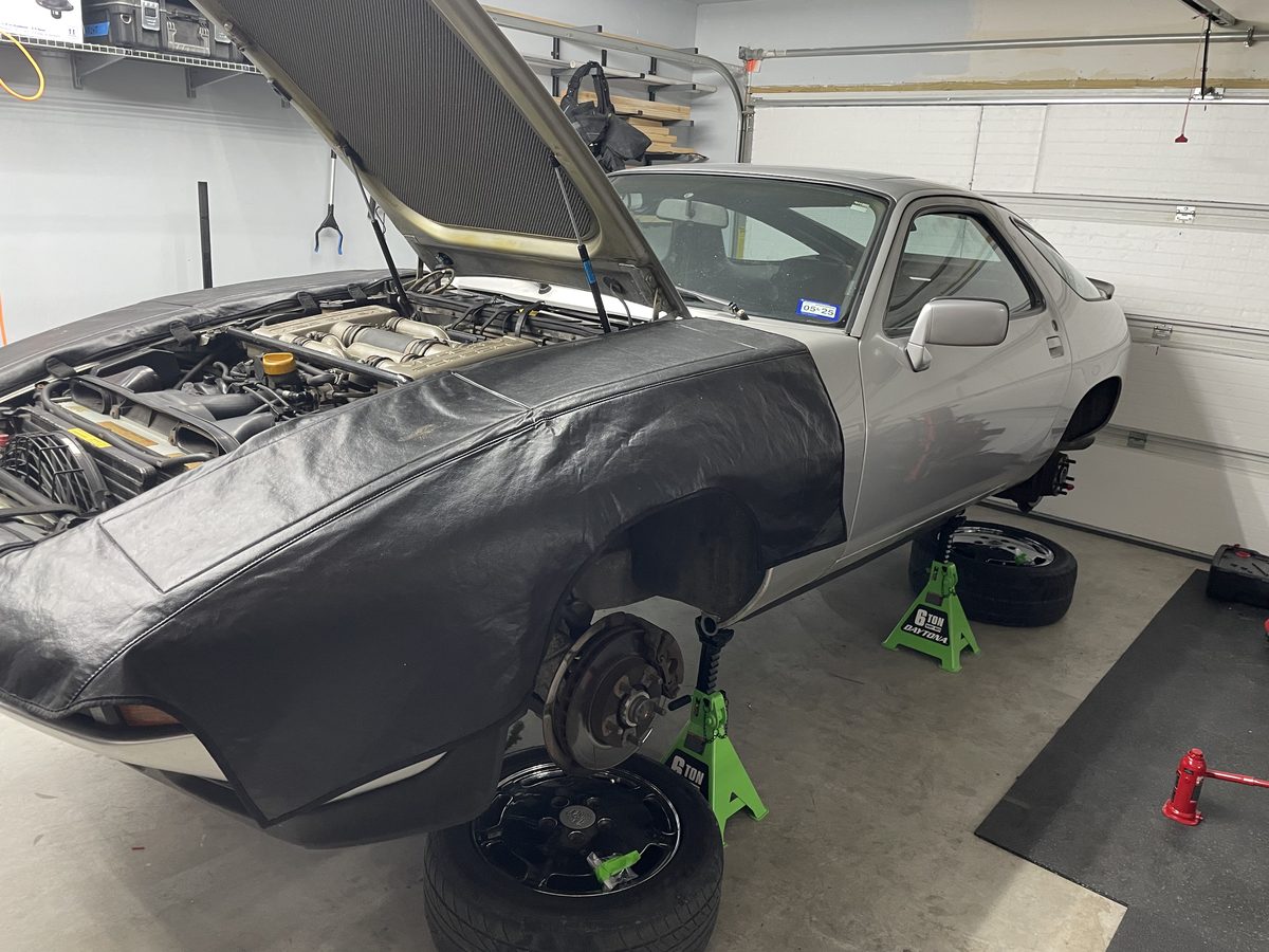 Porsche 928 raised on jack stands in the workshop during the wiring re-engineering project