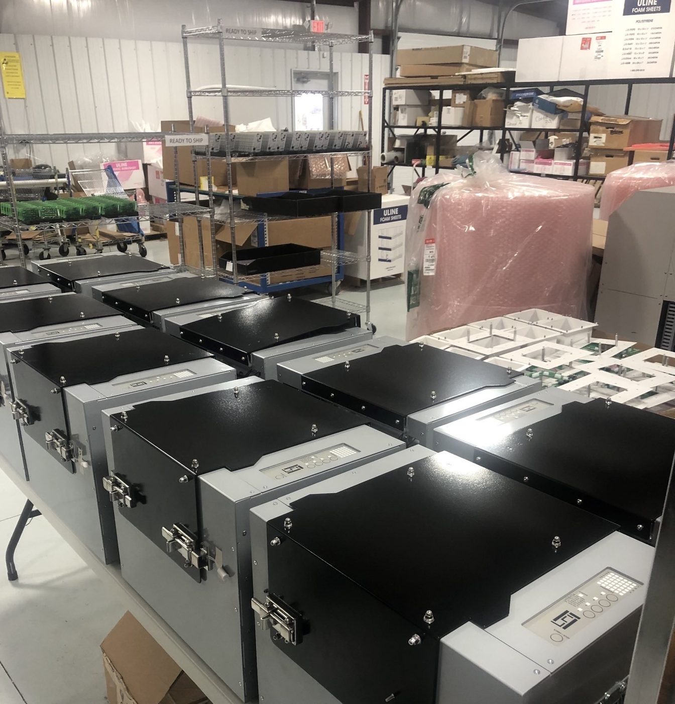 A fleet of finished RLX MK1 sterilizer units staged for shipping with READY TO SHIP shelving behind