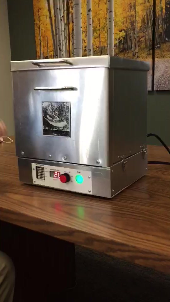 The Rushlight MK 3/4 Easy Bake — the first hand-fabricated UV-C prototype, sheet-metal enclosure with an exposure-level control panel, on a conference table